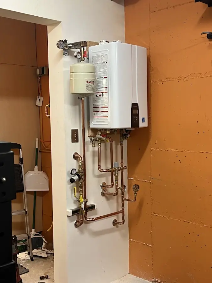 Plumbing technician inspecting water heater connections in Sandston